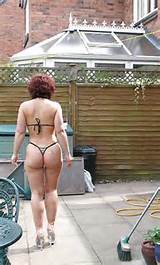 big butt milf housewife in her garden in thong bikini and heels