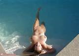 Nude MILF relaxing in pool